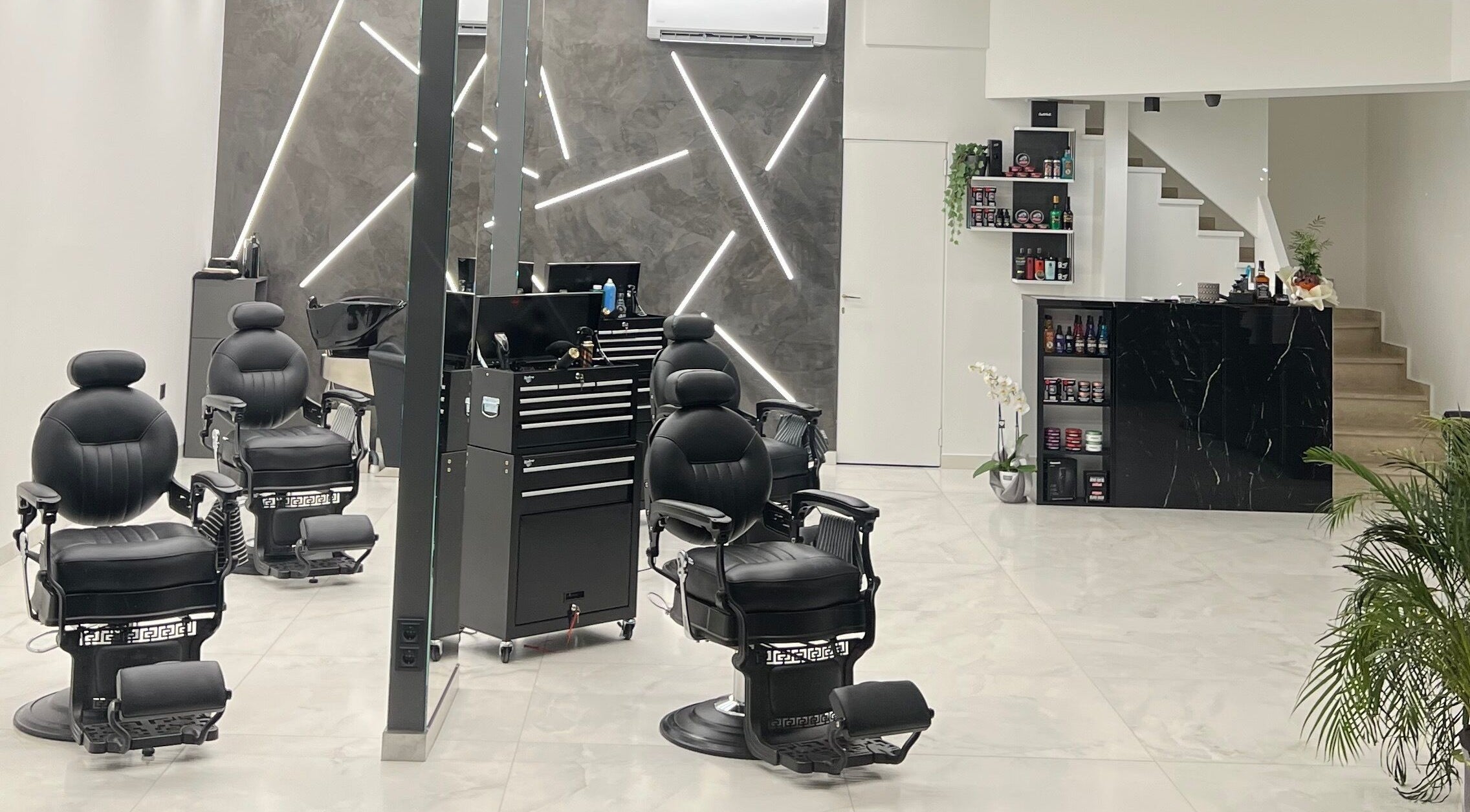 Εσωτερικό σύγχρονου κομμωτηρίου στο BarberCraft Hair Studio, Αθήνα, Αττικής, GR με πολυτελείς καρέκλες.