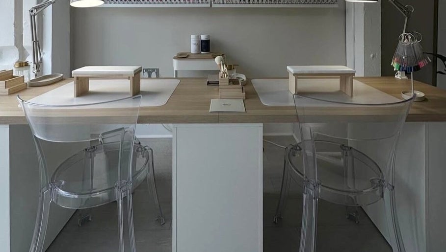 Modern nail station at No10 Beauty & Aesthetics in Woodbridge, England, GB, with clear chairs and elegant setup.