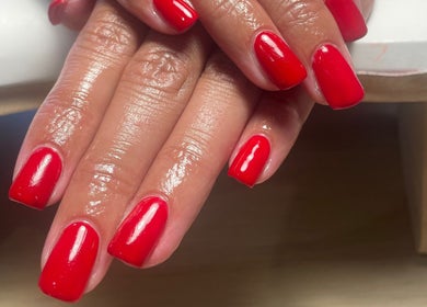 Glossy red nails beautifully manicured at No10 Beauty & Aesthetics, Woodbridge, England, GB.