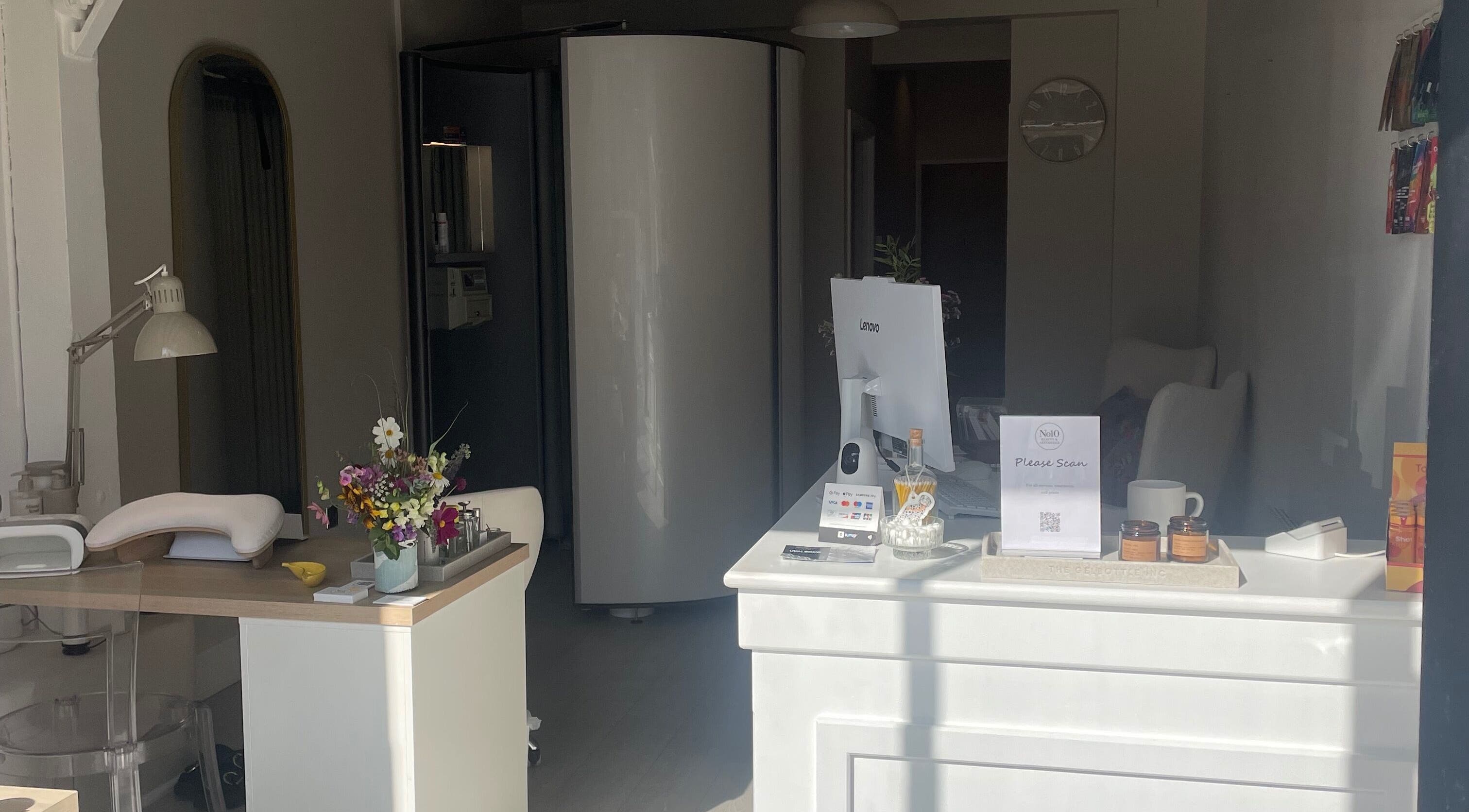Reception area at No10 Beauty & Aesthetics in Woodbridge, England showcasing treatment and welcome desk.