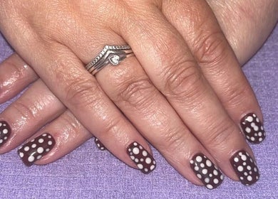 Polkadot nail design at Polished by Molly, Hedge End, England, GB enhances manicured hands with elegant style.
