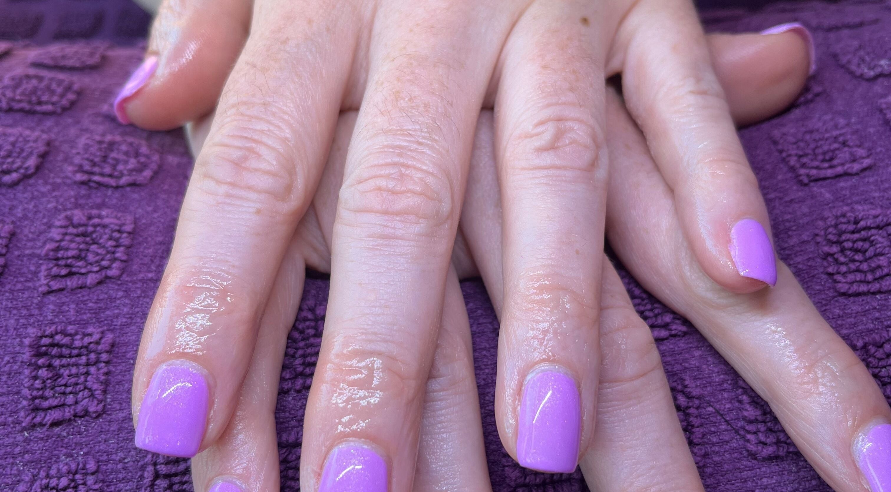Lavender manicured nails by Polished by Molly in Hedge End, England, GB, resting on a textured purple towel.