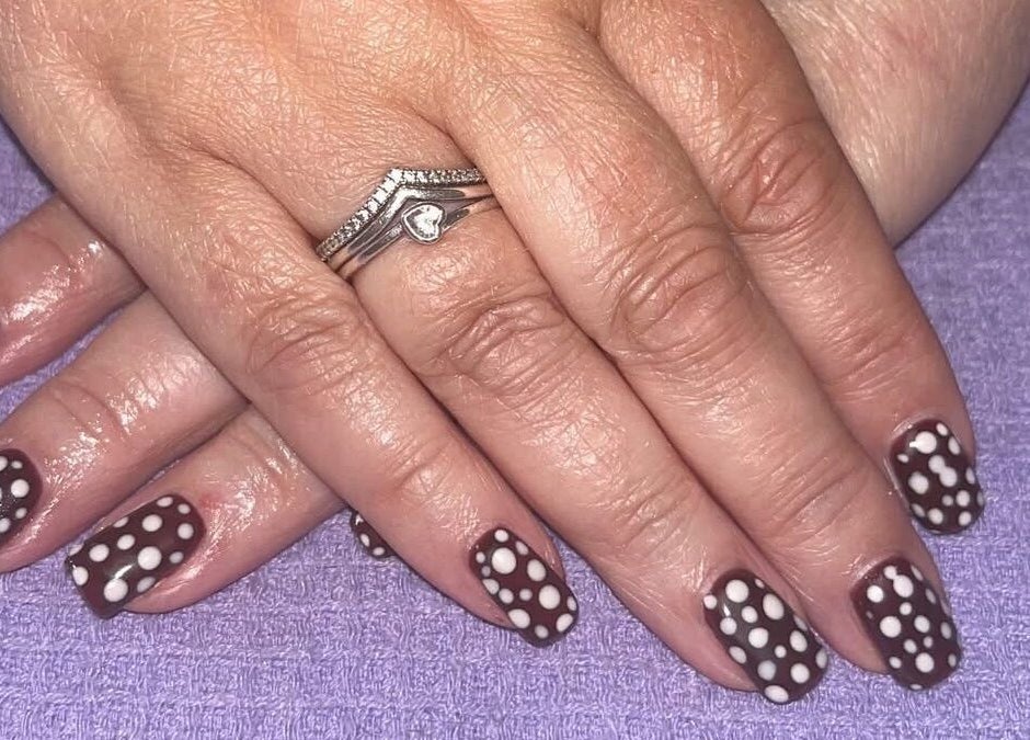 Polished by Molly in Hedge End, England, offers creative polka dot nail design on manicured hands.