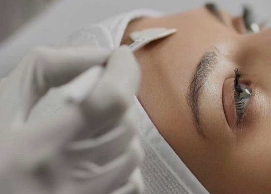 Facial treatment at Dotyk Beauty Therapy, London, England, GB. Close-up of eyebrow shaping with precision.