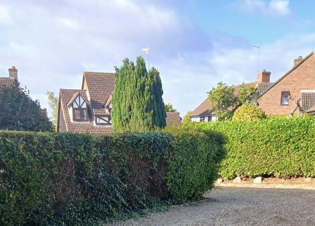 Picturesque view of quaint houses and lush hedges near Facial Massage Aigul, Northampton, England, GB.