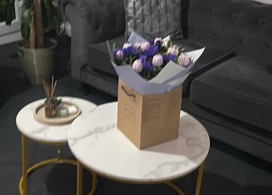 Sophisticated lounge area at Hair By Amina in London, England, GB, featuring a bouquet on stylish marble tables.