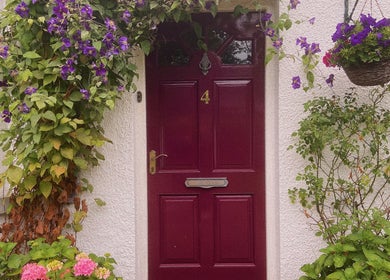 Charming red door with floral decor at Nails by Megan Caroline, Ballymena, Northern Ireland, GB.