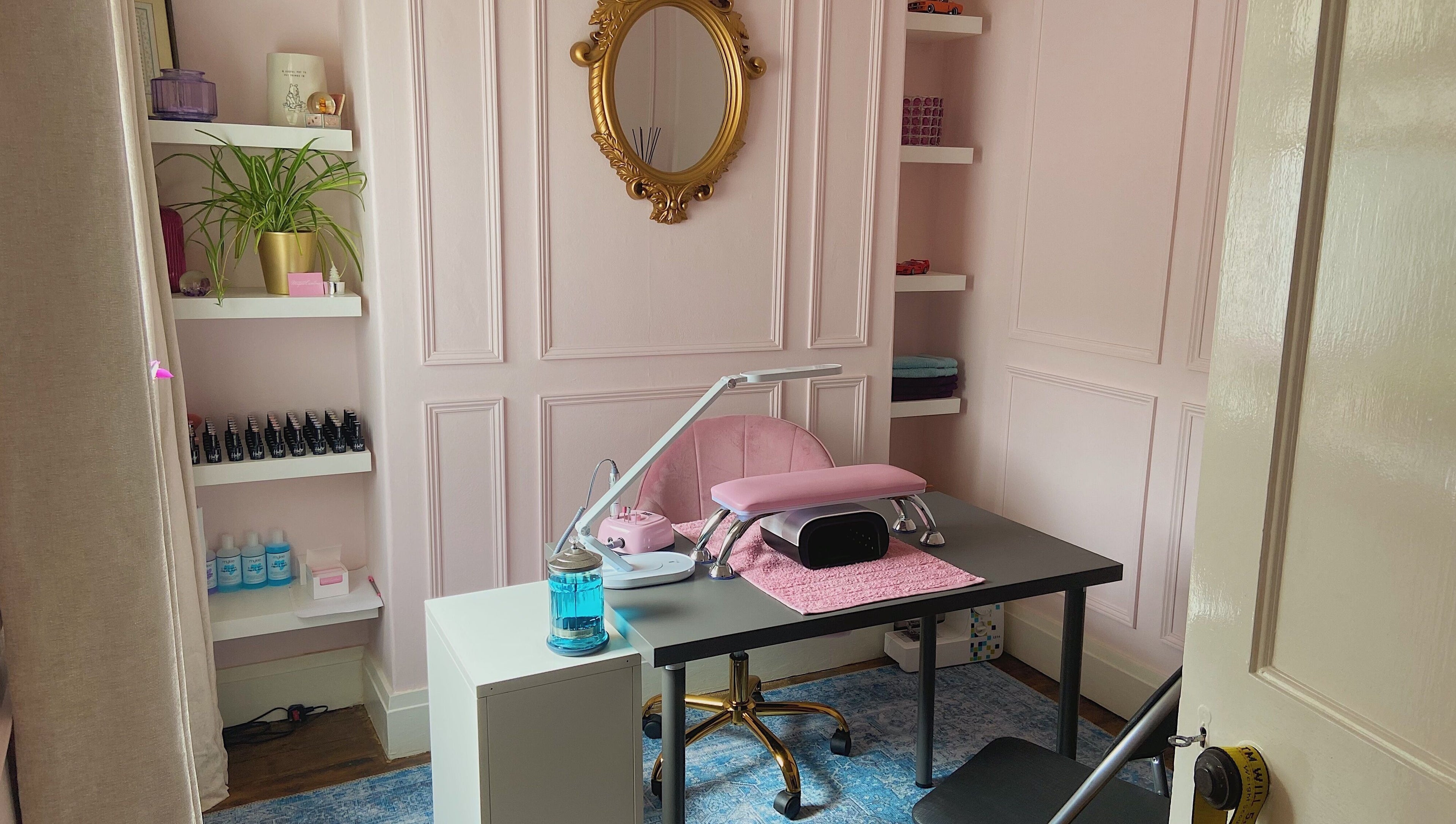 Elegant nail salon desk at Nails by Megan Caroline, Ballymena, Northern Ireland, GB with pink decor and gold mirror.