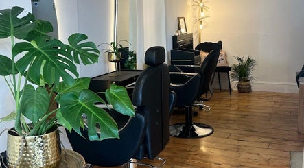 Sleek interior of Joshua Levi Hair in London, England, GB with stylish black chairs and lush plants.