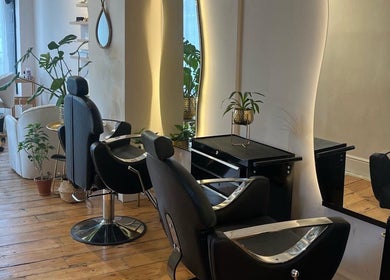 Stylish interior of Joshua Levi Hair in London, England, GB, featuring modern salon chairs and elegant mirrors.