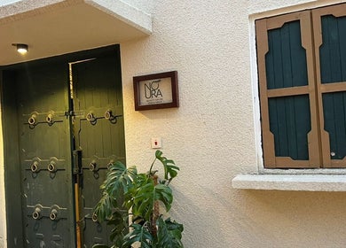 Entrance of Glowin Salon at Abha, Al Athar 7507, SA, featuring a stylish door and lush greenery.