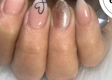 Close-up of a stylish nail art with glitter and heart design at Ella's Nails & Lash Studio Middelburg.