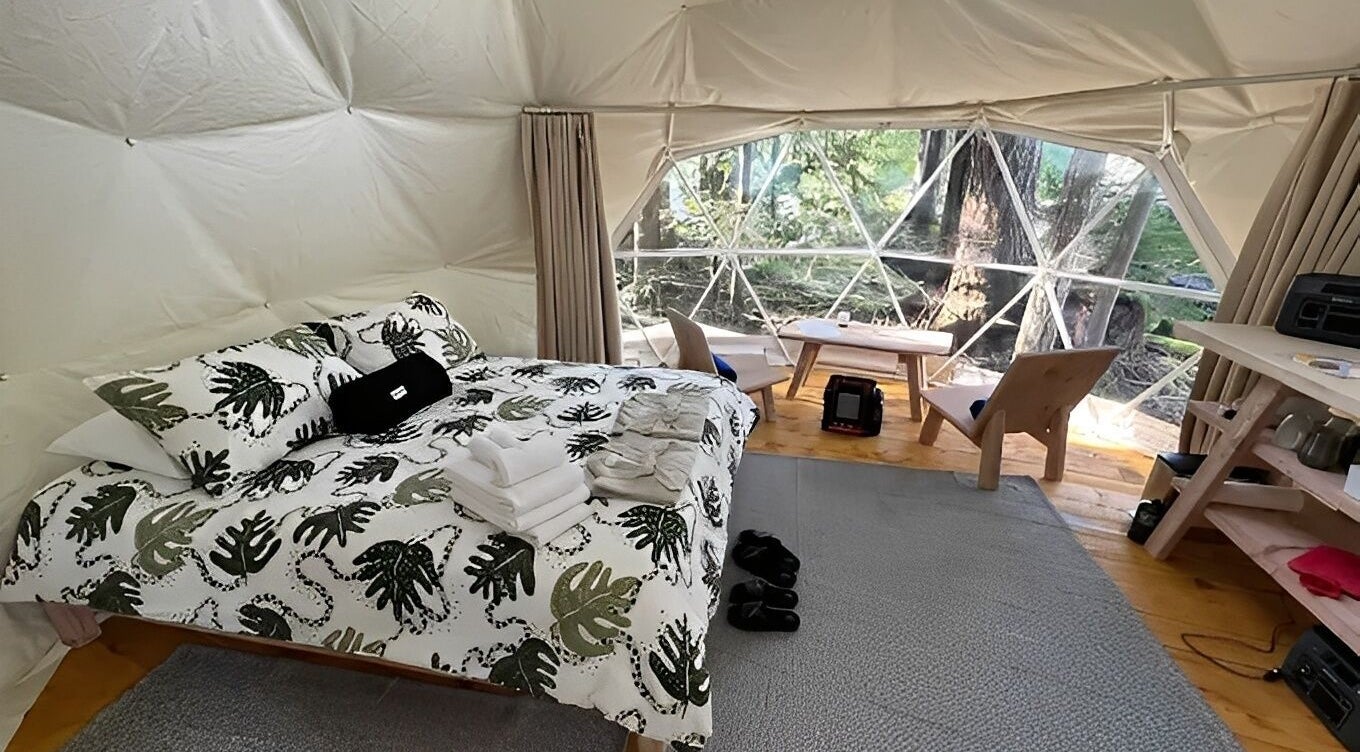 Cozy geodesic dome interior at Stay Wilder, Sechelt, British Columbia, CA, with forest views and chic decor.