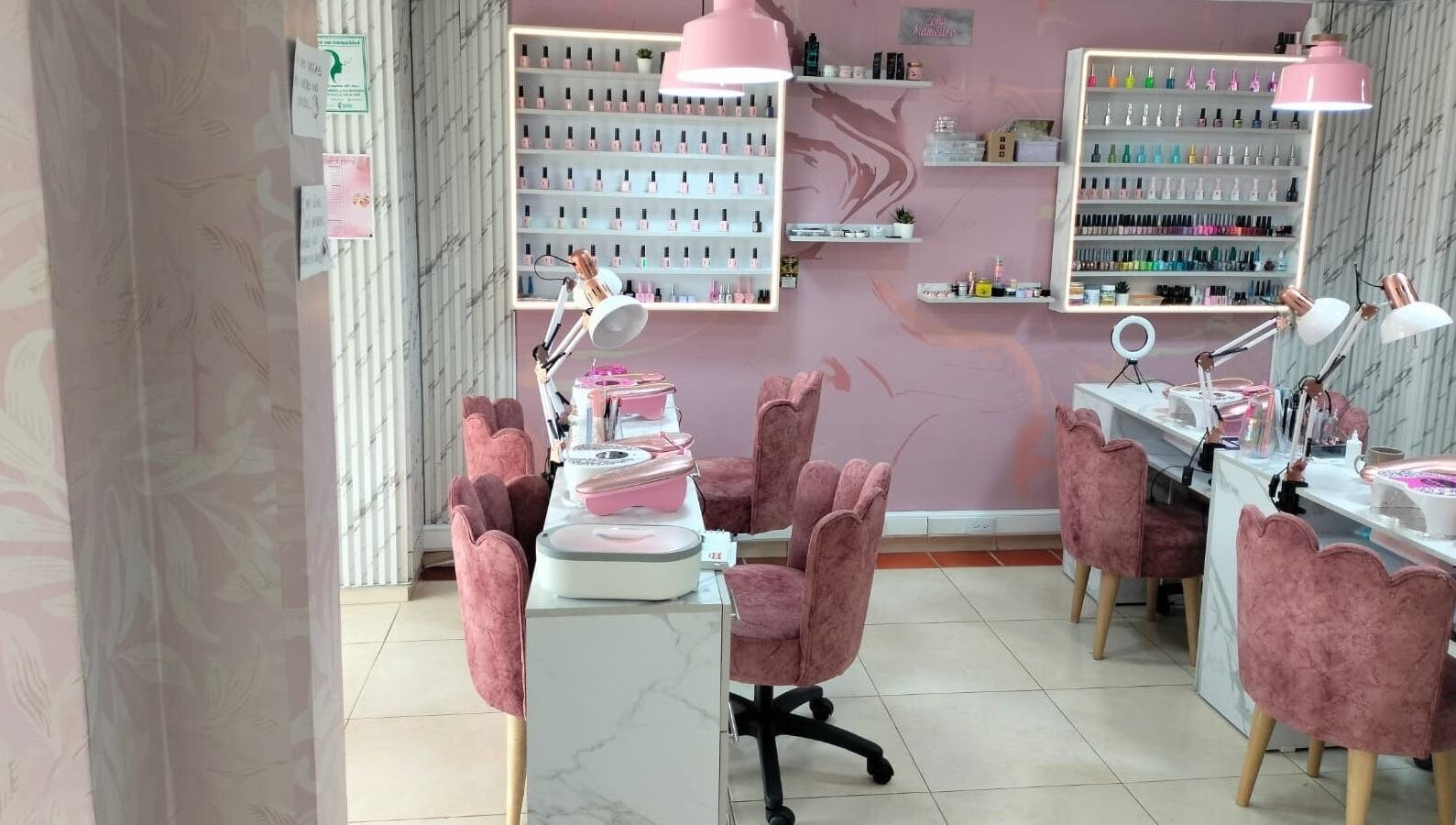 Interior elegante de Tendencia Studio en Bogotá, Bogotá, CO con sillas rosas y mesas de manicura.