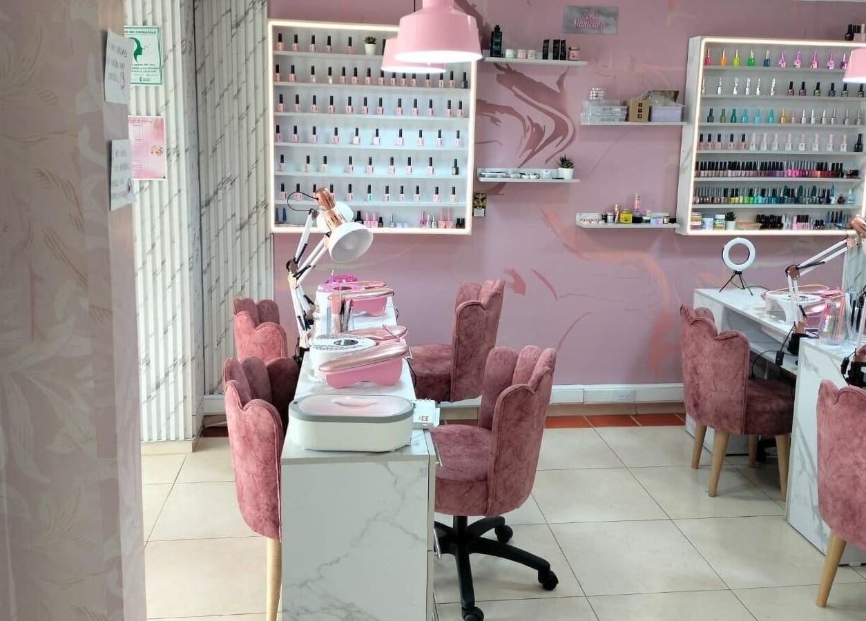 Interior elegante de Tendencia Studio en Bogotá, Bogotá, CO con sillas rosas y mesas de manicura.