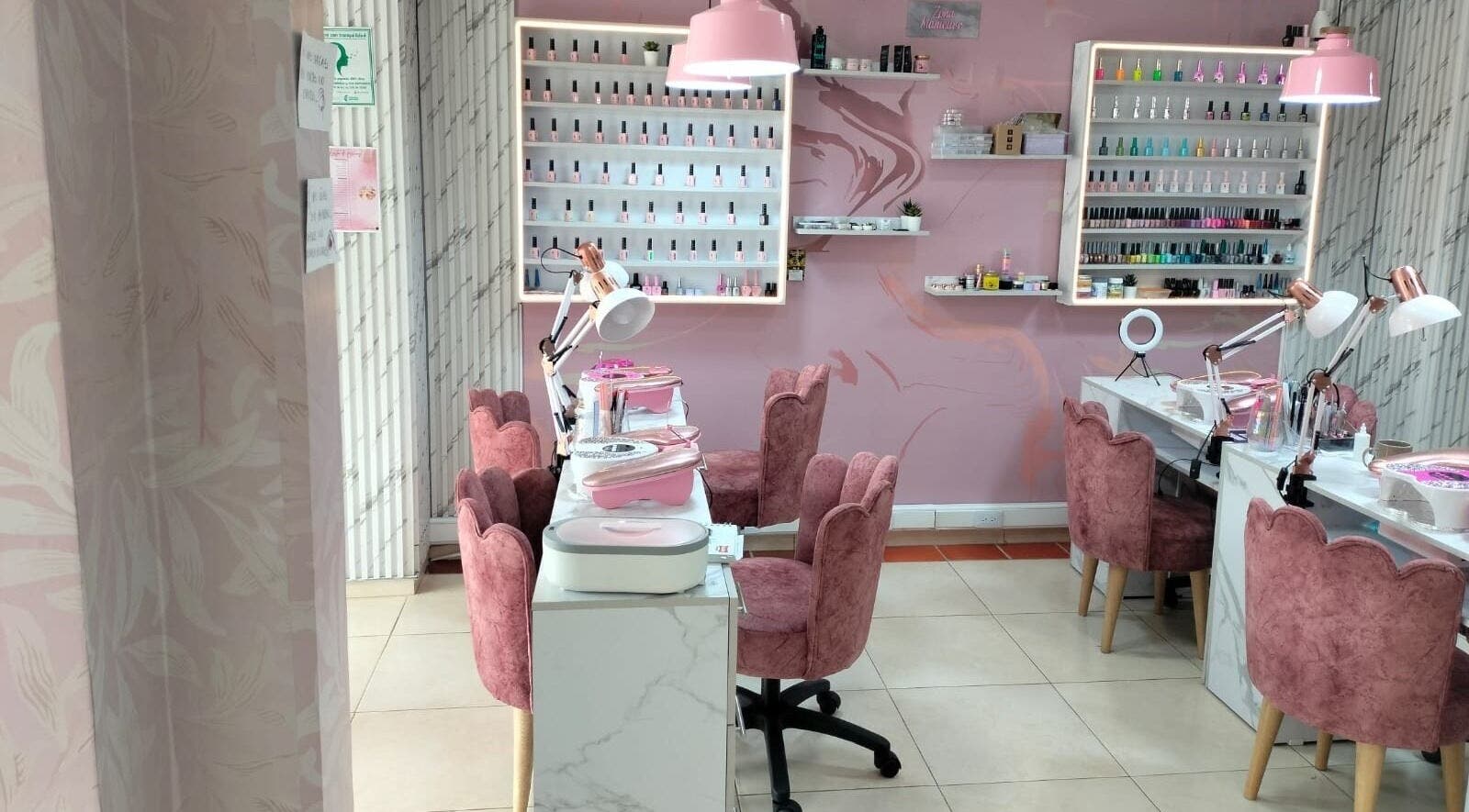 Interior elegante de Tendencia Studio en Bogotá, Bogotá, CO con sillas rosas y mesas de manicura.