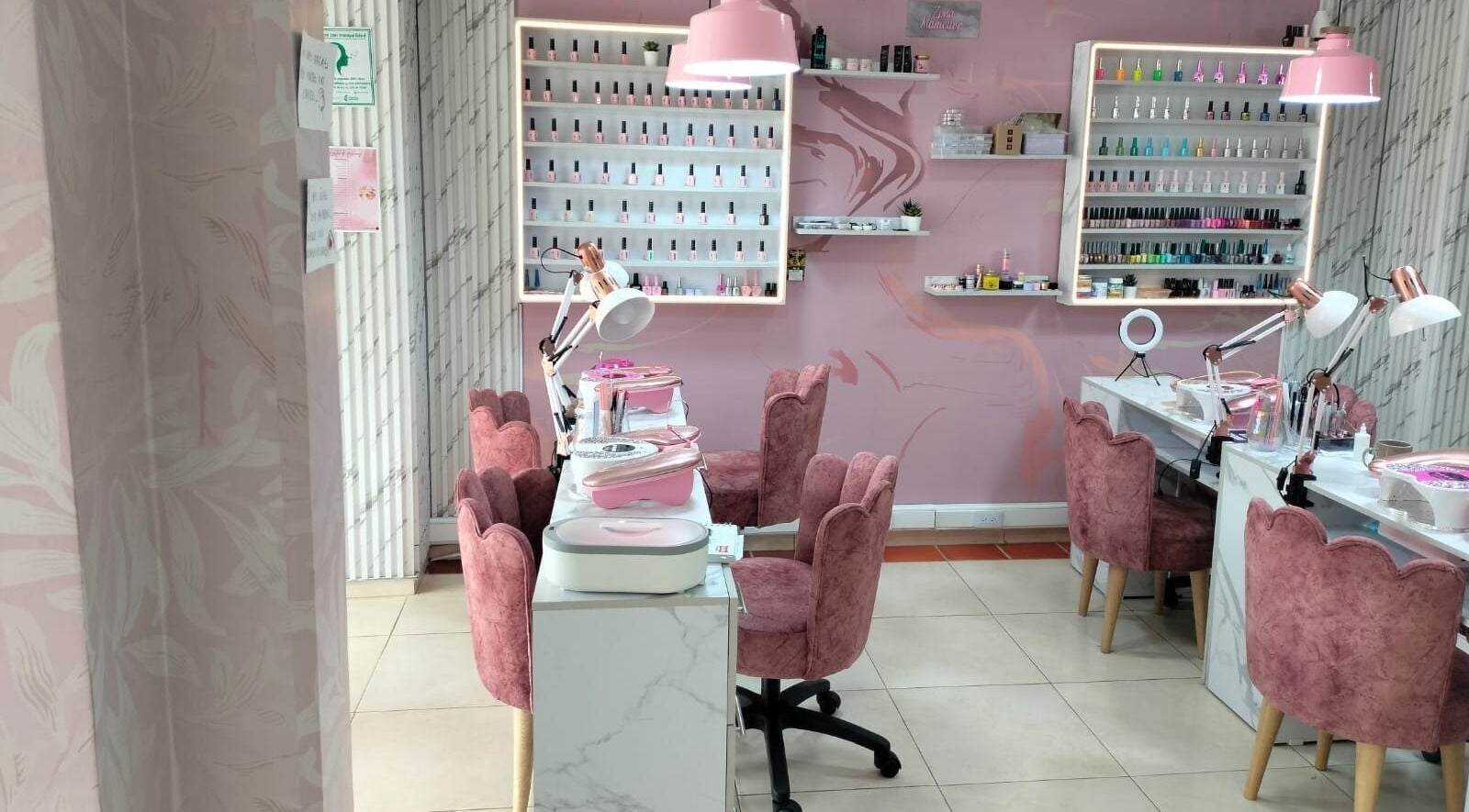 Interior elegante de Tendencia Studio en Bogotá, Bogotá, CO con sillas rosas y mesas de manicura.