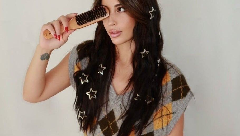 Woman with star hair accessories using brush at Silk Tech Hair, NORTH MIAMI, Florida, US.