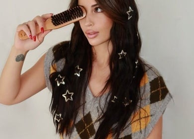 Woman with star hair accessories using brush at Silk Tech Hair, NORTH MIAMI, Florida, US.