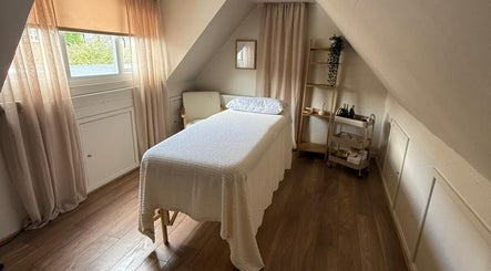 Relaxing treatment room at Lola & Bloom, Stanstead Abbotts, England, GB with cozy bed and soft lighting.