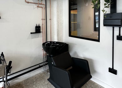 Modern salon wash station at Cammarata Studio, London, England, GB, showcasing sleek design and styling products.