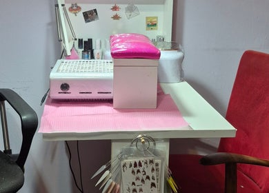 Estación de manicura en Tita & Co. Nails, Buenos Aires, AR, con lámpara UV y variedad de esmaltes.