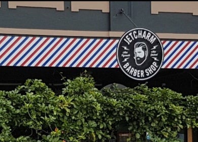 Entrance of Jetcharm Barbershop & Gentlemen’s Quarters in New Plymouth, Taranaki Region, NZ with striped awning.