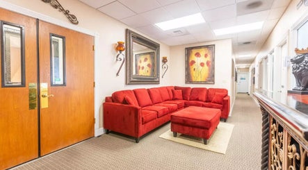Inviting red sofa in Placer Therapeutic Massage lobby, Roseville, California, US, with elegant decor.