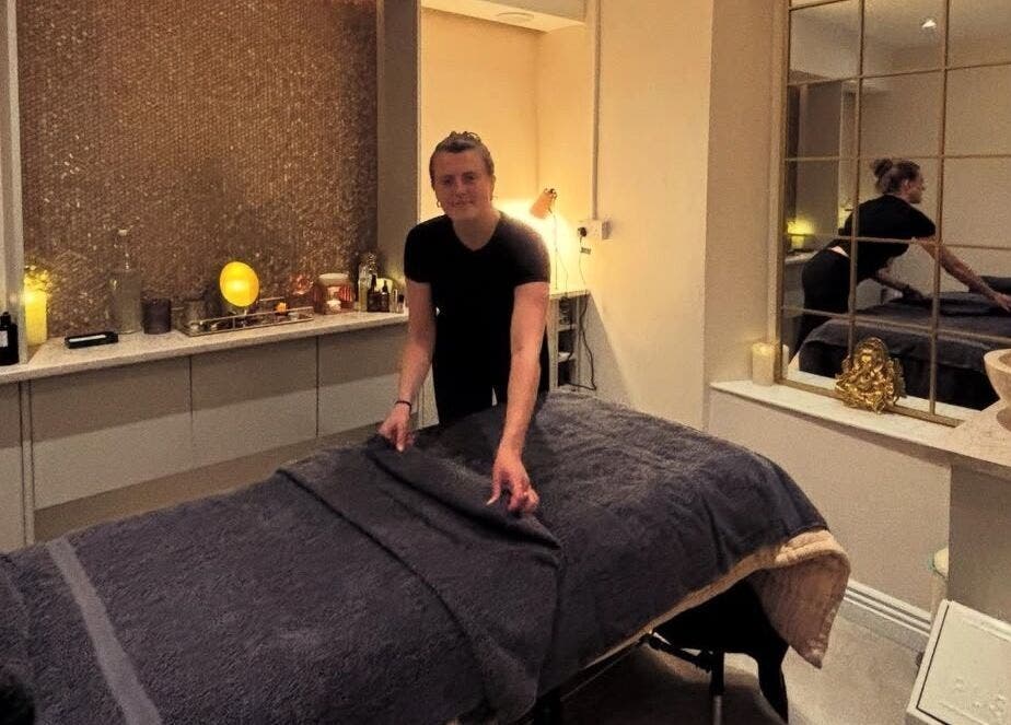 Massage therapist at TULA AYURVEDA in Frome, England, GB prepares a tranquil treatment room.