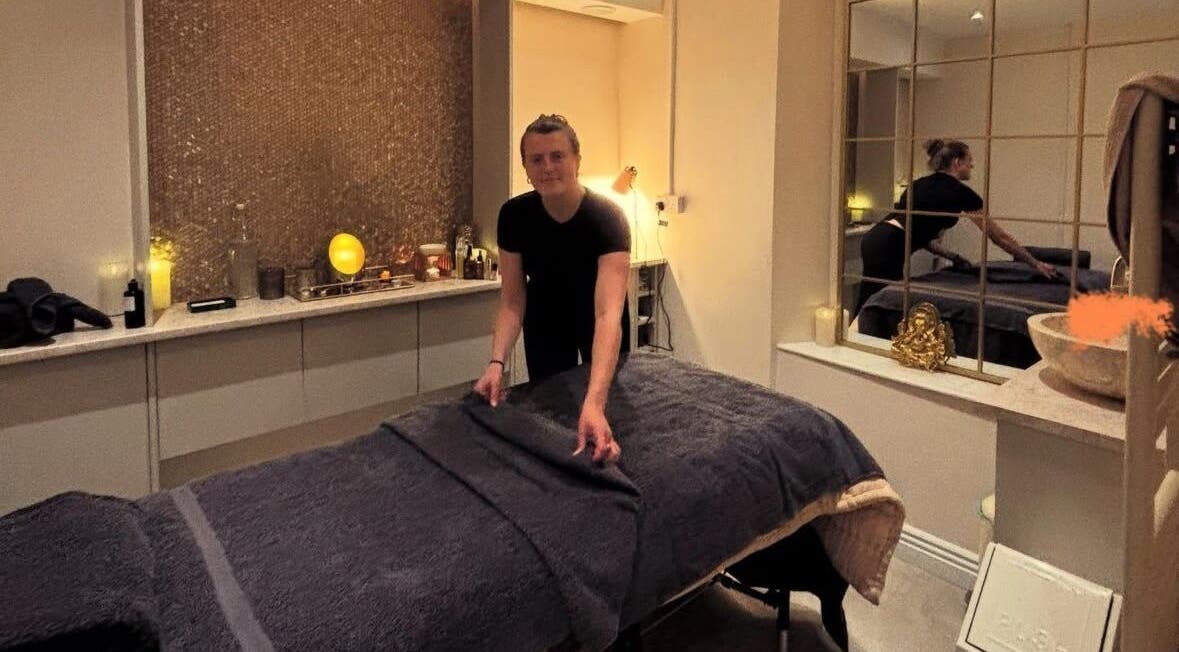 Massage therapist at TULA AYURVEDA in Frome, England, GB prepares a tranquil treatment room.