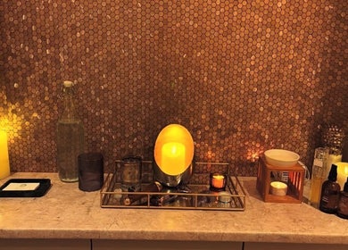 Warm candlelit display at TULA AYURVEDA, Frome, England, GB, enhancing the soothing ambiance with wellness products.