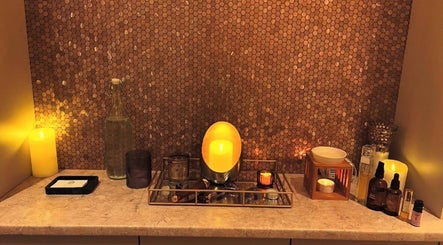 Warm candlelit display at TULA AYURVEDA, Frome, England, GB, enhancing the soothing ambiance with wellness products.