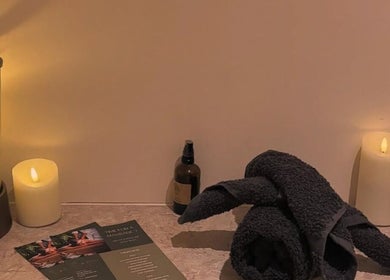 Relaxing massage room at TULA AYURVEDA, Frome, England, GB with candles and rolled towels.