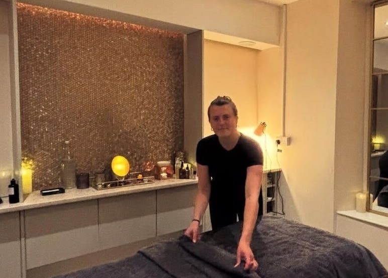 Practitioner preparing treatment room at Tula Ayurveda, Frome, England, GB for a calming wellness session.