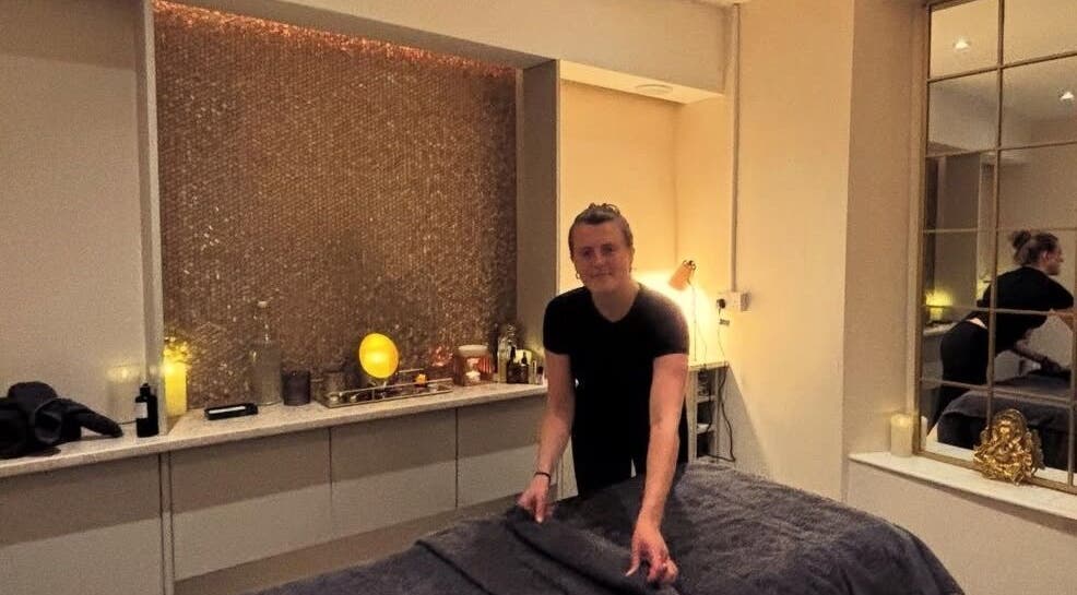 Practitioner preparing treatment room at Tula Ayurveda, Frome, England, GB for a calming wellness session.