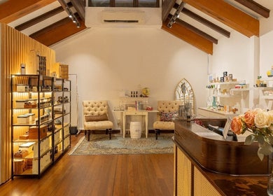 Cozy interior of Roses & More Skin Alchemy featuring plush chairs and wooden shelves, Singapore, Singapore, SG.