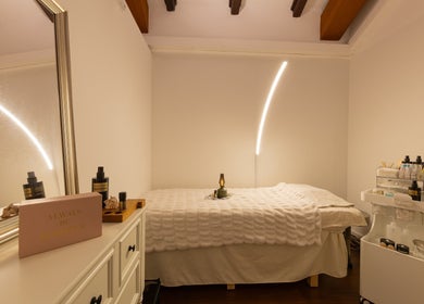 Cozy treatment room at Roses & More Skin Alchemy, Singapore, SG with soft lighting and skincare products.