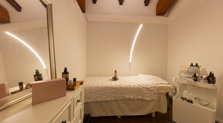 Cozy treatment room at Roses & More Skin Alchemy, Singapore, SG with soft lighting and skincare products.