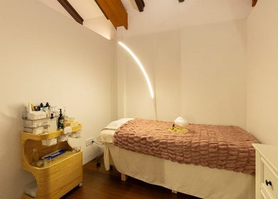 Relaxing spa room at Roses & More Skin Alchemy, Singapore, SG with a massage bed and warm lighting.