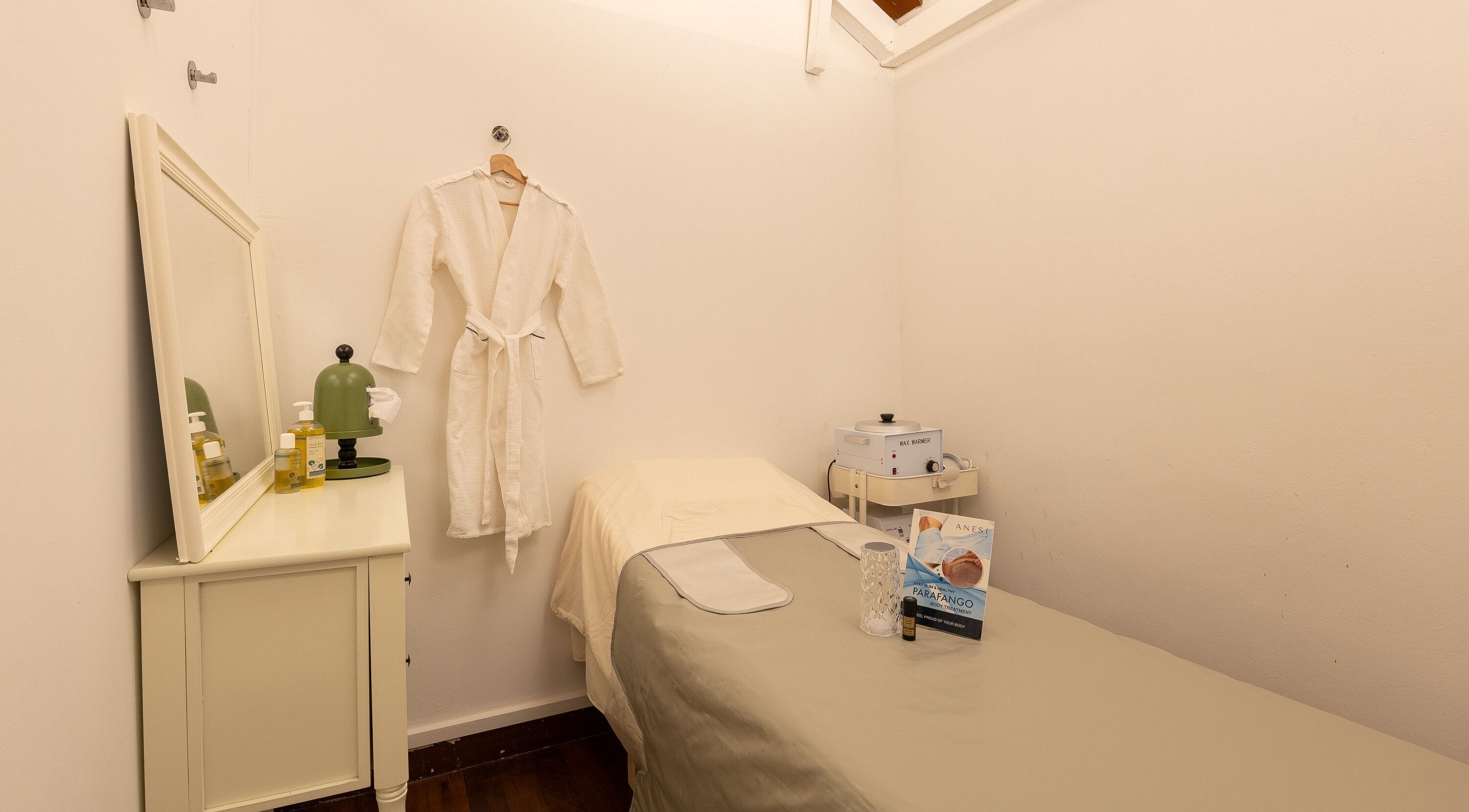 Serene treatment room at Roses & More Skin Alchemy, Singapore, SG with cozy robe and massage bed.