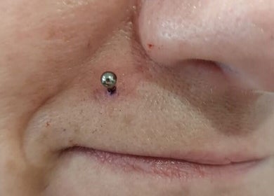 Close-up of nose piercing at Elysian Beauty and Piercing, enhancing style in Sudbury, GB.