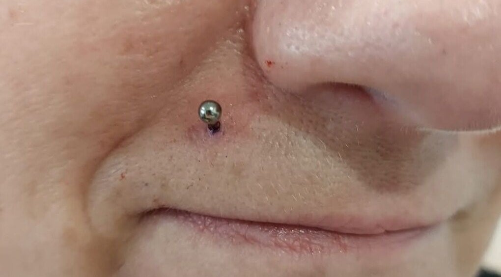 Close-up of nose piercing at Elysian Beauty and Piercing, enhancing style in Sudbury, GB.
