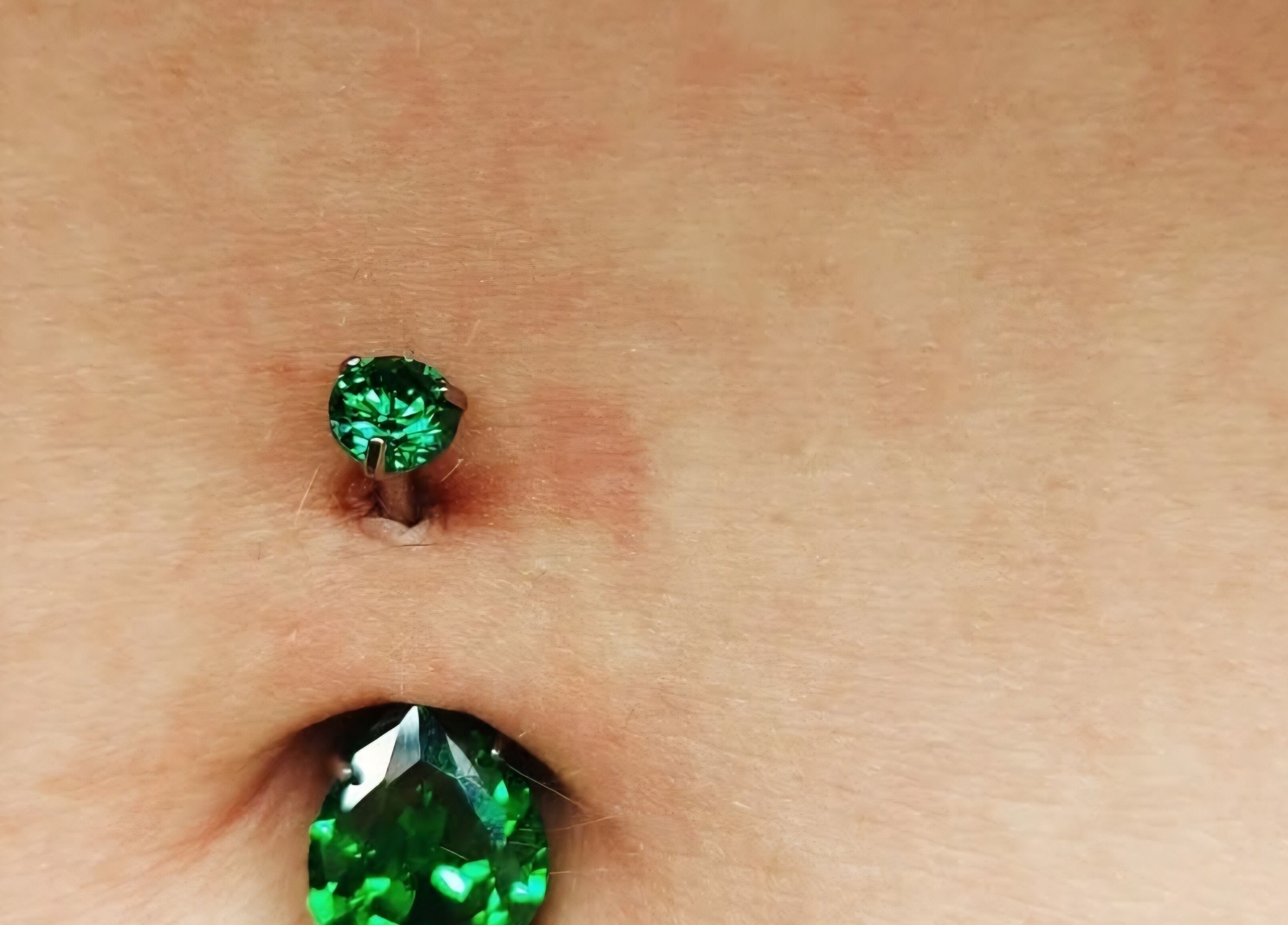 Green gemstone navel piercing at Elysian Beauty and Piercing, Sudbury, GB enhances elegance and style.