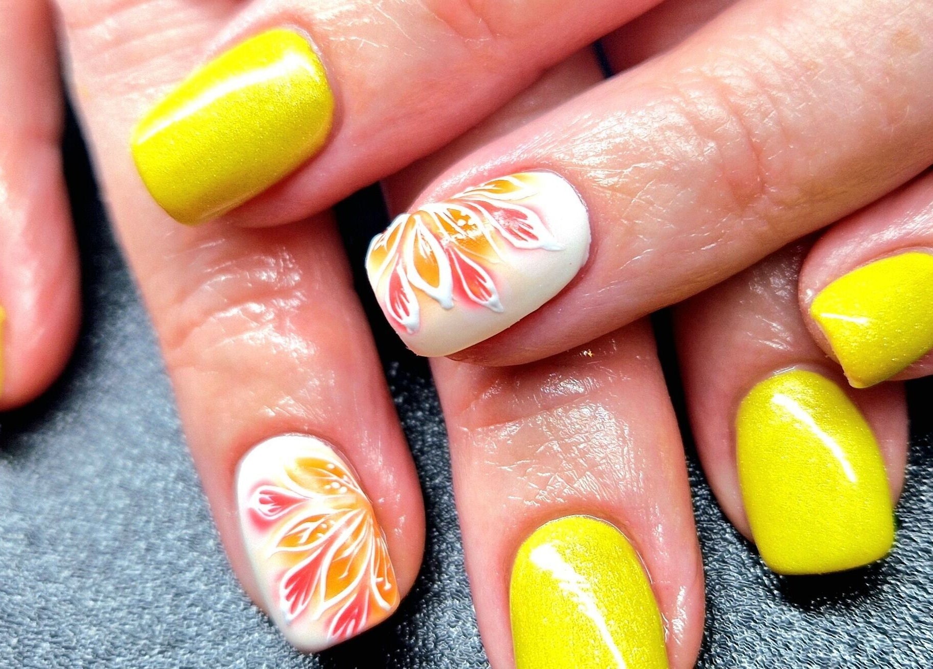 Vibrant yellow and floral nail art at Elysian Beauty and Piercing, Sudbury, GB. Perfect for summer styles.