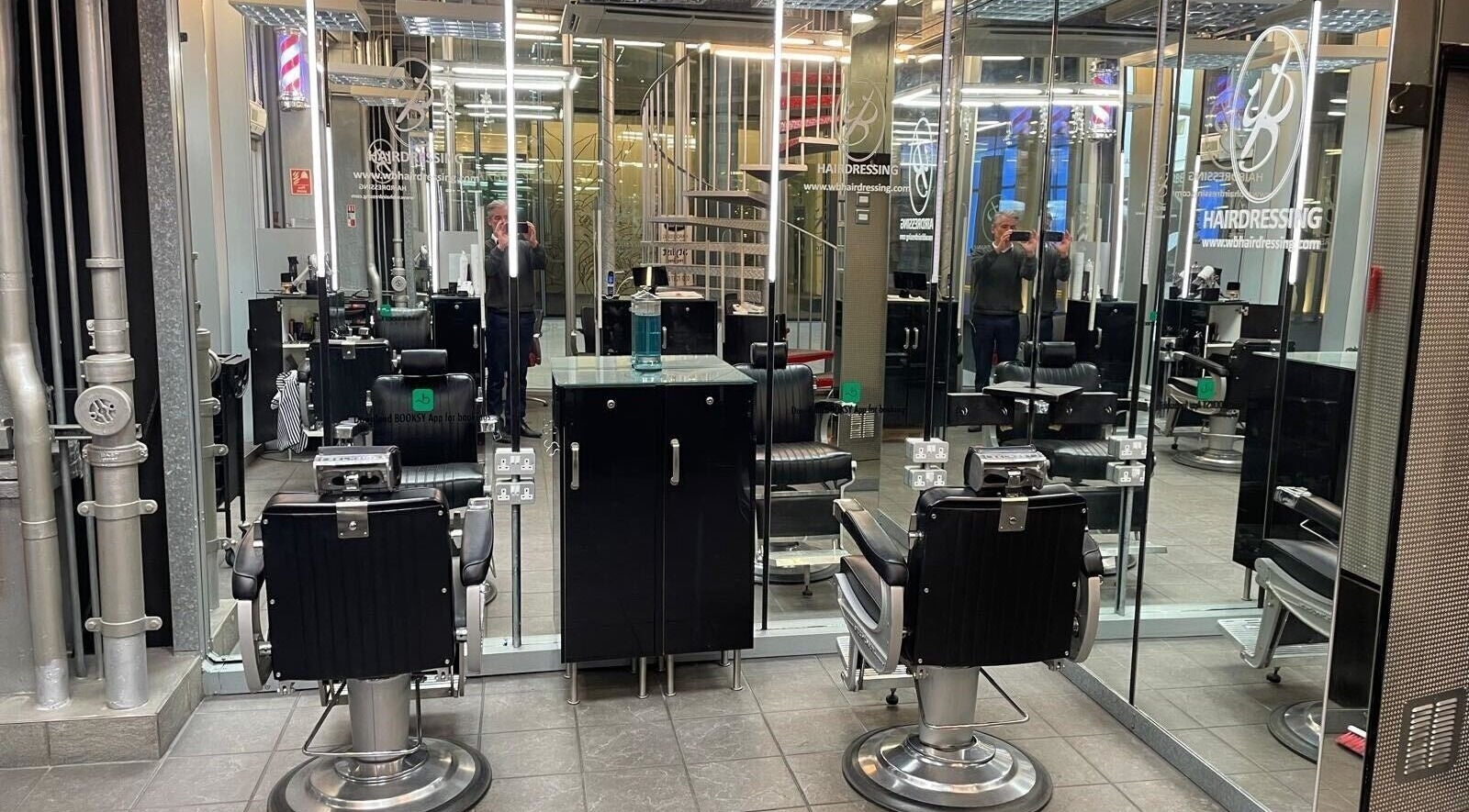 Modern salon chairs and mirrors at WB Hairdressing, London, GB showcasing sleek design.