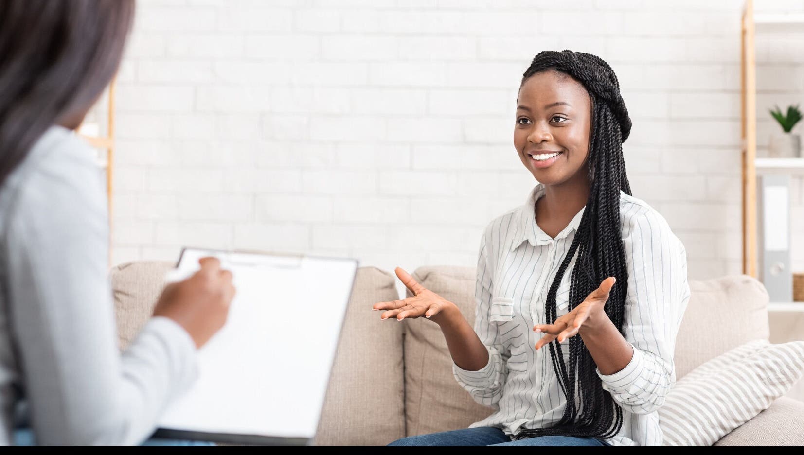 A client enjoying a session at Mindful Moments Wellness Hub in Johannesburg, ZA, with a therapist taking notes.