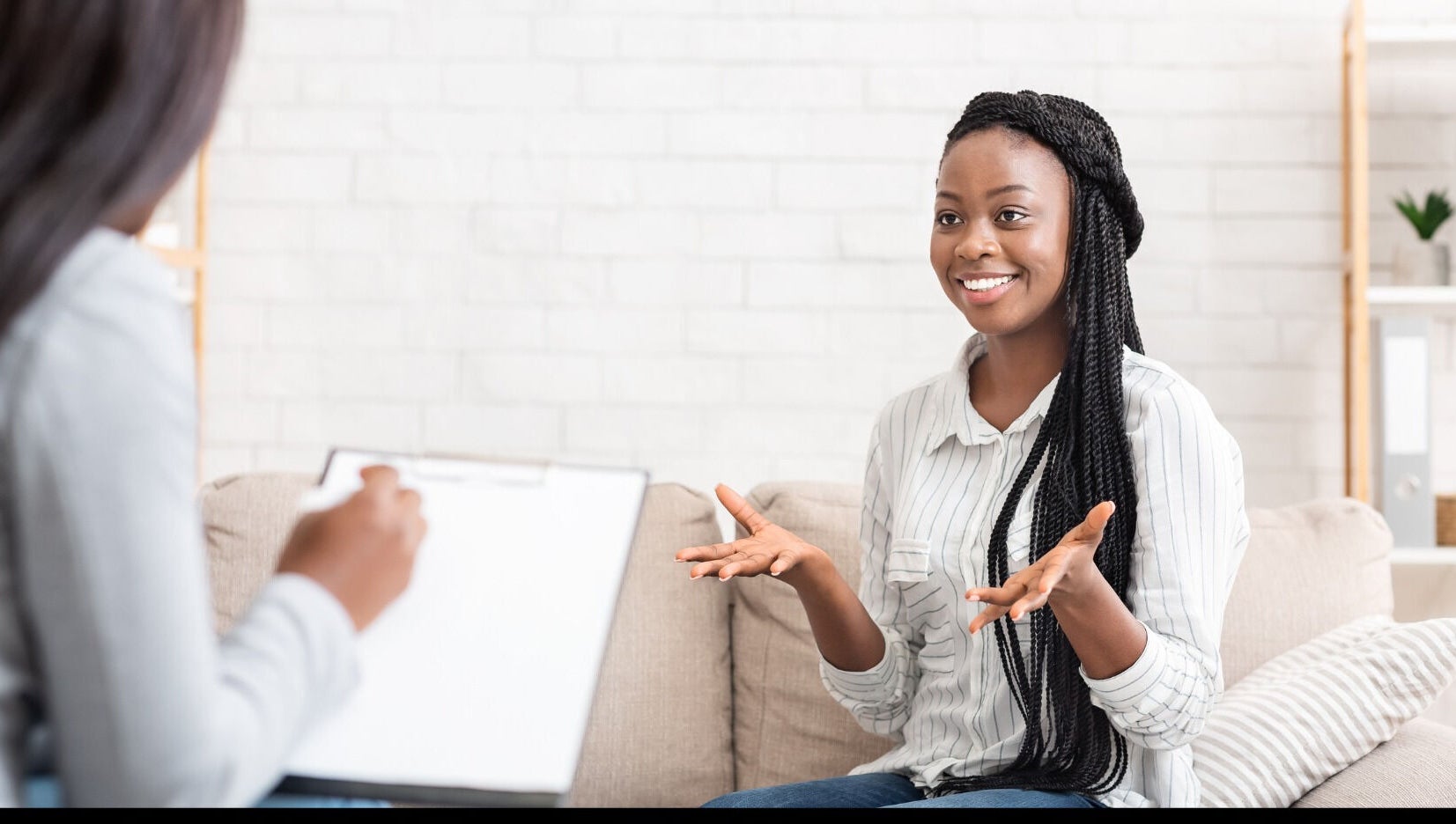 A client enjoying a session at Mindful Moments Wellness Hub in Johannesburg, ZA, with a therapist taking notes.
