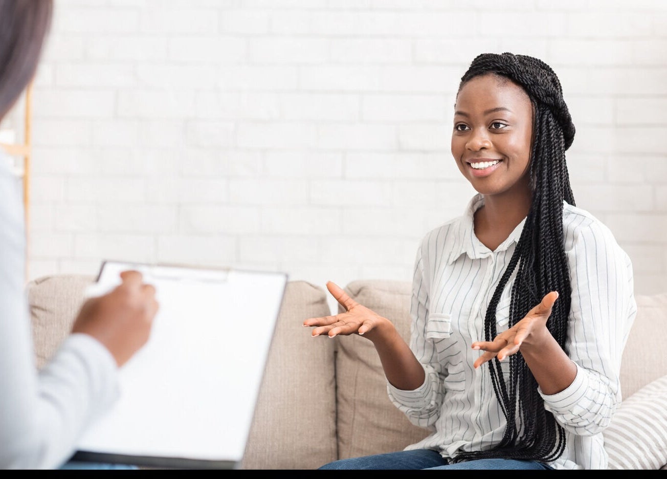 A client enjoying a session at Mindful Moments Wellness Hub in Johannesburg, ZA, with a therapist taking notes.