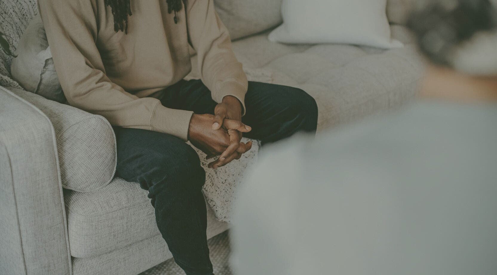 Individual sitting on a cozy couch at Mindful Moments wellness Hub, Johannesburg, ZA, promoting relaxation.