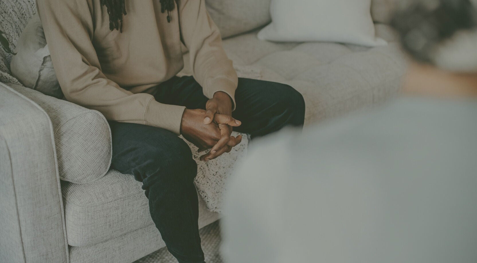 Individual sitting on a cozy couch at Mindful Moments wellness Hub, Johannesburg, ZA, promoting relaxation.